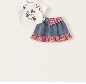 Macro detail of white cotton T-shirt with bunny print and red checkered denim skirt set