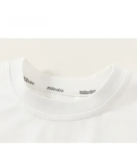 Detailed macro view of the ribbed crew neck collar on a white cotton kids T-shirt
