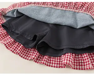 Detail view of girl's red plaid skirt featuring a built-in black safety shorts lining
