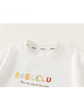 Detail des weißen Baumwoll-T-Shirt-Ausschnitts mit buntem BOBOCLUB-Aufdruck und weichem Stoff