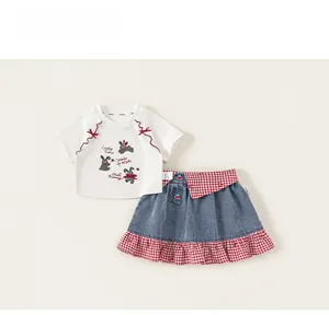 Flat lay of girls' white cotton T-shirt with bunny print and checkered denim skirt