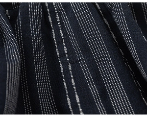 Detailed view of dark navy striped cotton fabric texture with vertical dotted pattern