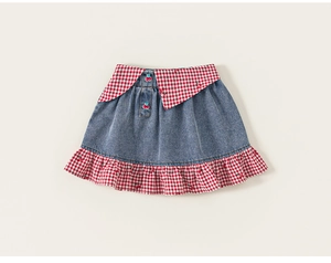 Detail of girls denim skirt with red gingham collar waist and cherry pattern buttons
