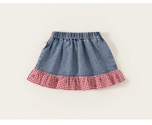 Detail of girls' denim skirt with red and white plaid ruffle hem and elastic waistband