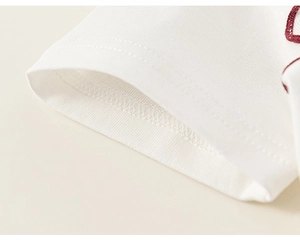 Detail shot of white cotton knit fabric with reinforced double stitching and red piped edges