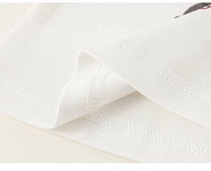 Detailed close-up showing precision stitching on the hem of a white cotton fabric garment
