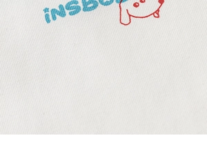 Close-up of kids white cotton T-shirt featuring blue iNS text and red puppy graphic