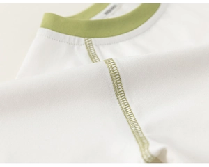 Detail of green contrast stitching and ribbed collar on high-quality white cotton kid's T-shirt