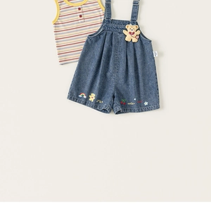 Detail of baby denim overalls with 3D bear pendant and colorful cartoon embroidery