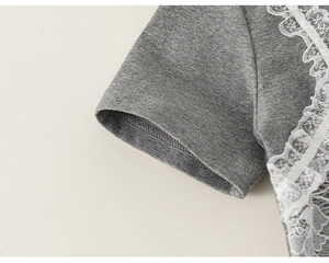 Detail of grey cotton T-shirt sleeve with delicate white lace trim and fine stitching