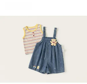 Detail of baby summer outfit with striped vest and denim overalls featuring a 3D bear