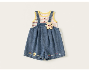 Macro shot of 3D yellow bear plush and rainbow embroidery on denim overalls