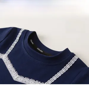 Detail shot of navy cotton girl shirt showing white lace collar and fine fabric texture