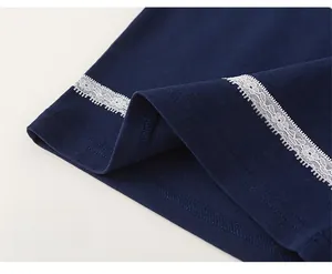 Detail of navy knit t-shirt featuring intricate white lace trim on the loose hemline