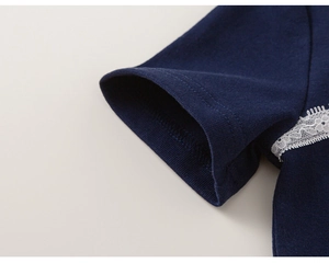Detail shot of navy blue cotton t-shirt sleeve with delicate white lace trim and stitching