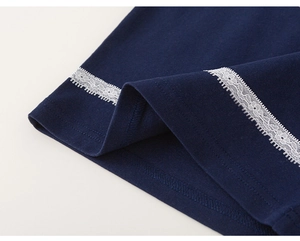 Detailed close-up of navy blue knit fabric with white lace trim on the girls' t-shirt