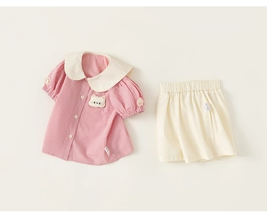 Detail of pink plaid shirt with Peter Pan collar and white cotton skirt set for girls