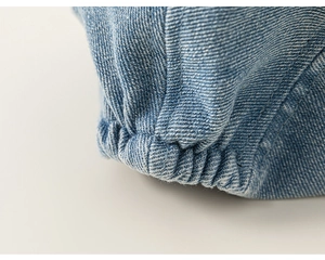 Detail of blue denim fabric texture and elastic hem design on children's beret hat