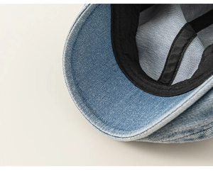 Detailed macro view of light blue washed denim beret with precision stitching and sweatband