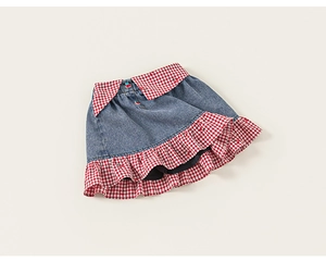 Détails d'une jupe en jean pour fille avec coutures à carreaux et broderie cerise