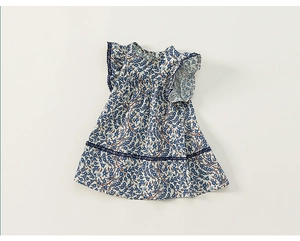 Dettaglio dell'abito floreale blu da bambina con pizzo blu scuro e maniche a volant