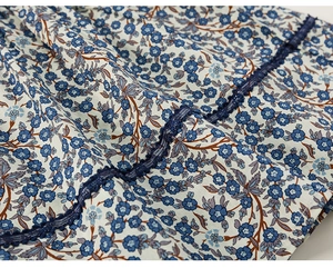 Dettaglio del tessuto in cotone a fiori blu con ricamo in pizzo blu scuro