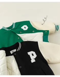 Detailed view of kids varsity jacket with green fabric and white quilted lining