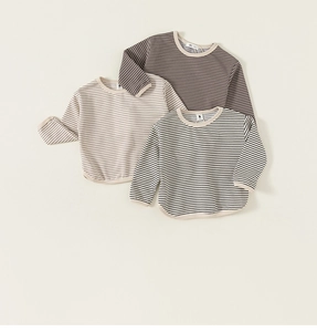 Detailed close-up of three striped long-sleeve cotton t-shirts for kids in various colors