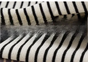 Close-up of black and white striped knit fabric with soft ribbed texture and premium cotton feel