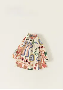 Détail d'une robe chemise pour enfant avec imprimés gribouillis colorés et col boutonné