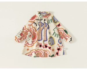 Détail de motifs graffiti colorés sur une robe chemise à manches longues crème pour fille