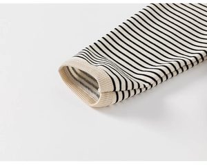 Detailed macro view showing the ribbed cuffs and knit texture of a black and white striped tee