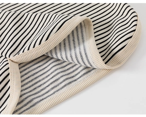 Detailed close-up of the black and white striped knit fabric and neck ribbing detail