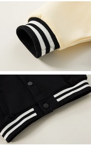 Detail showing high-quality ribbed cuffs and matte snap buttons of the varsity jacket