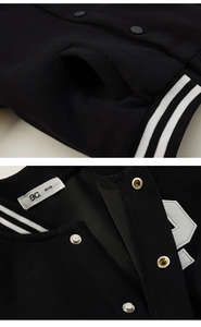 Detail of black kids' bomber jacket showing ribbed cuffs and snap button closure