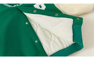 Detail view of green baseball jacket showing quilted lining and silver snap buttons