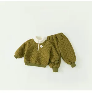 Detail of baby winter quilted set in green featuring fleece stand collar and flower accent