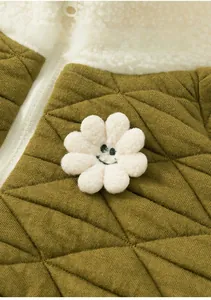 Detail of olive green quilted kids jacket with fleece collar and plush flower patch