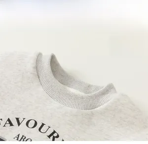 Detailed close-up of ribbed crewneck collar and FAVOUR print on grey cotton sweatshirt