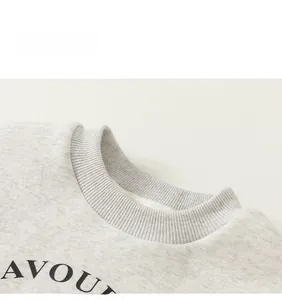 Close-up of light grey fleece sweatshirt with ribbed crew neck and black letter print