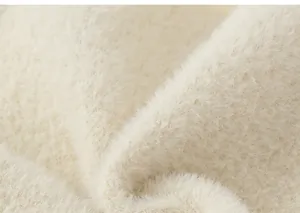 Detailopname van zachte crèmekleurige pluche fleece stof voor winterse warmte