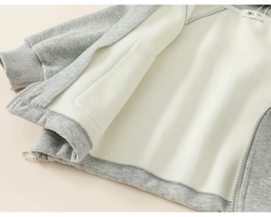 Detail view of children's grey knit jacket showing soft cream fleece lining and rib cuffs