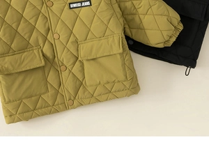Detail of quilted kids jackets in ginger and black with snap buttons and pockets