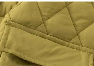 Detail of quilted diamond pattern and pocket stitching on kids' yellow winter jacket