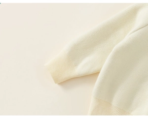 Detail van de geribbelde gebreide manchetten en zoom op de beige wintertrui voor kinderen