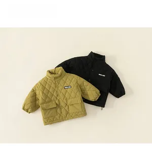 Detail view of mustard green and black quilted jackets for children with large front pockets