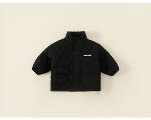 Detail of children's black quilted jacket with diamond patterns and utility pockets