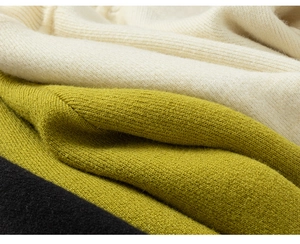 Detailopname van zachte ribgebreide stof in de kleuren crème, olijfgroen en zwart
