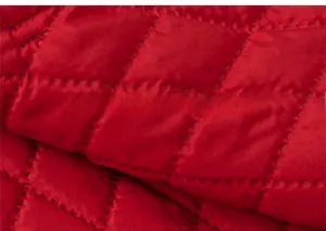 Gros plan détaillé du tissu matelassé rouge à losanges pour vêtements d'hiver festifs d'enfants