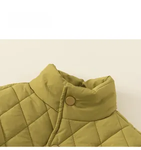 Detail of quilted mustard green jacket collar with snap button and standing collar design